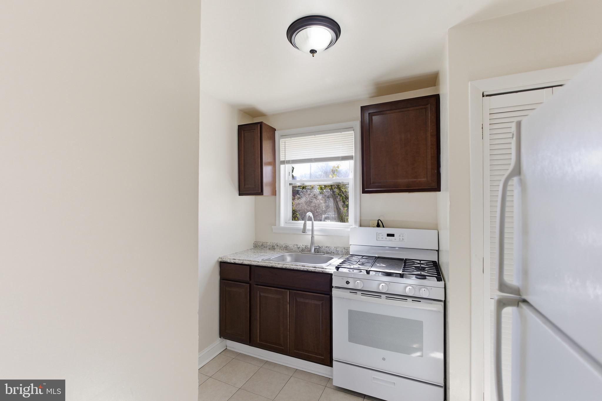 101 Wayne Place Southeast, Unit 2 Washington, DC 20032 - Photo 4 of 10 a kitchen with stainless steel appliances granite countertop a sink and a stove with refrigerator