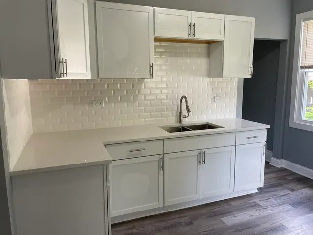 a kitchen with white cabinets and a sink