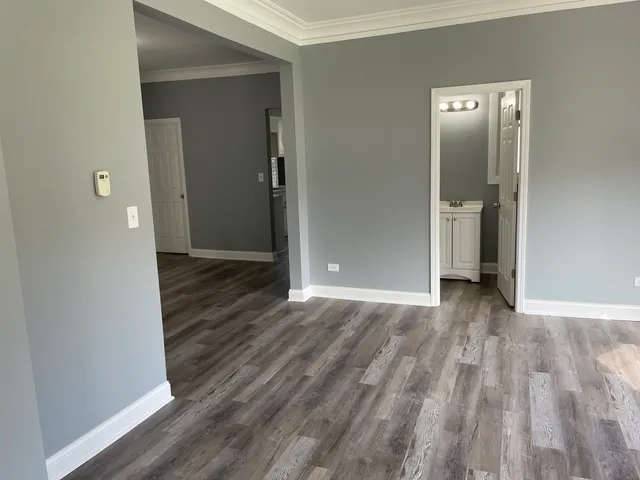 wooden floor with a bench in a room