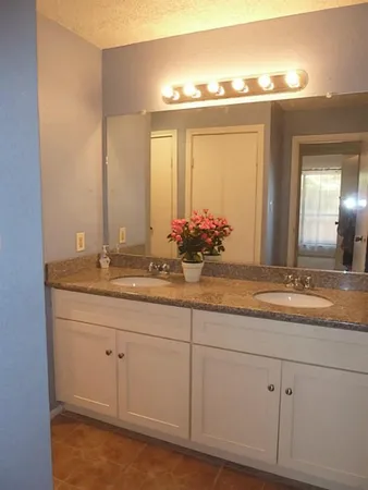 a bathroom with double sink and a mirror
