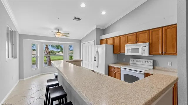 a kitchen with stainless steel appliances granite countertop a stove a refrigerator a sink dishwasher a dining table and chairs with wooden floor