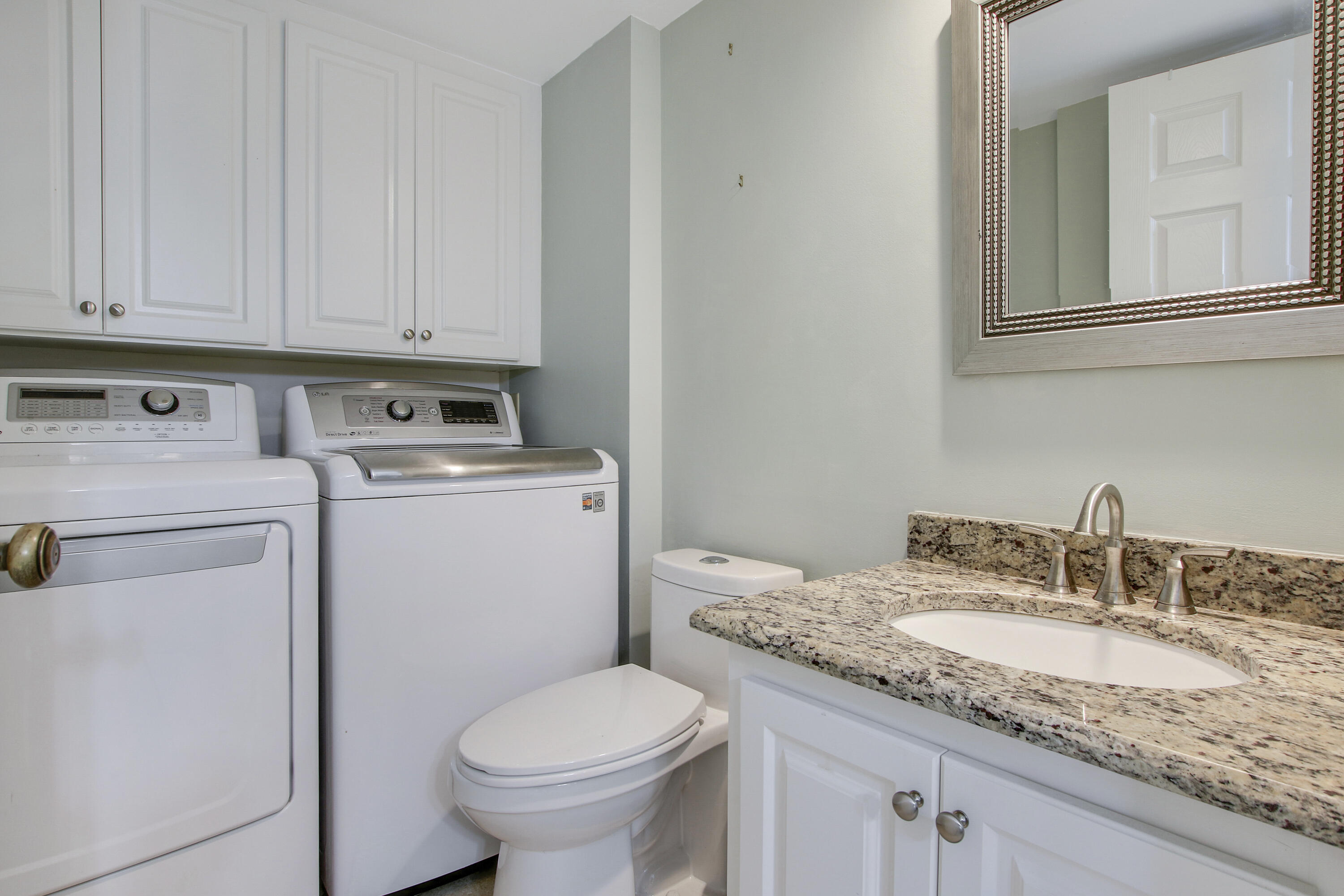 1205 12th Court Jupiter, FL 33477 - Photo 13 of 13 a bathroom with a granite countertop toilet sink and mirror