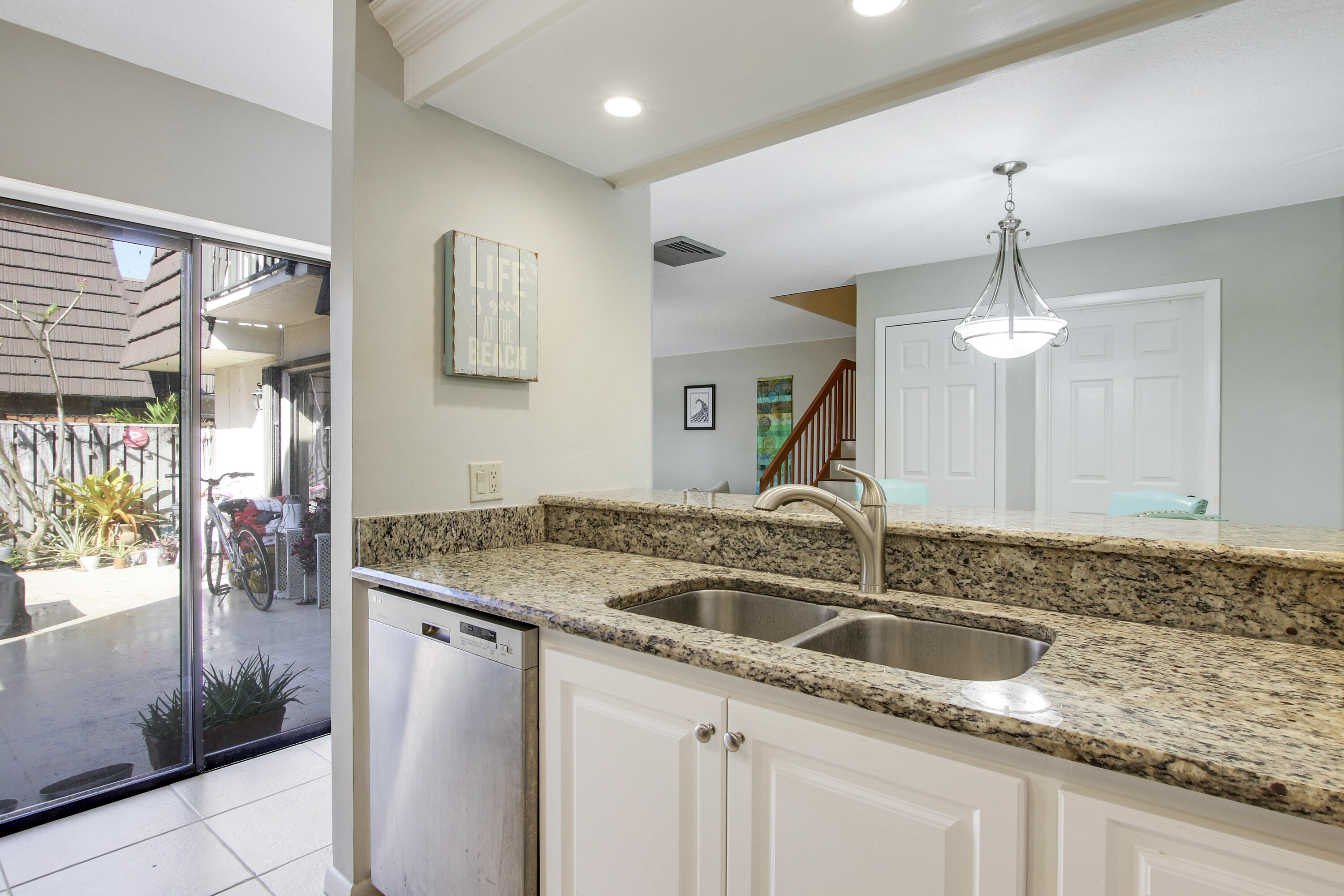 1205 12th Court Jupiter, FL 33477 - Photo 7 of 13 a kitchen with a sink and a refrigerator