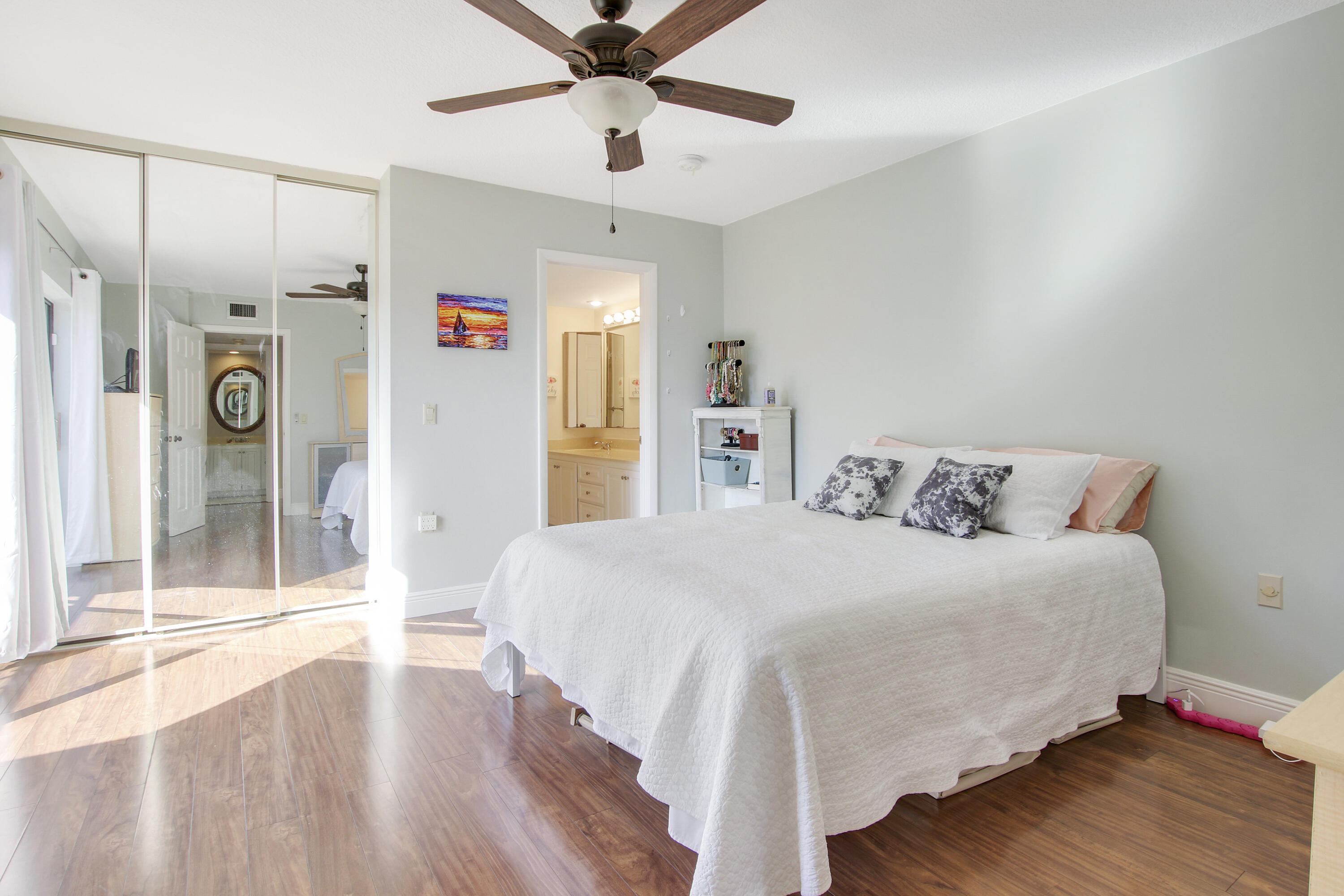 1205 12th Court Jupiter, FL 33477 - Photo 9 of 13 a spacious bedroom with a bed and a chandelier