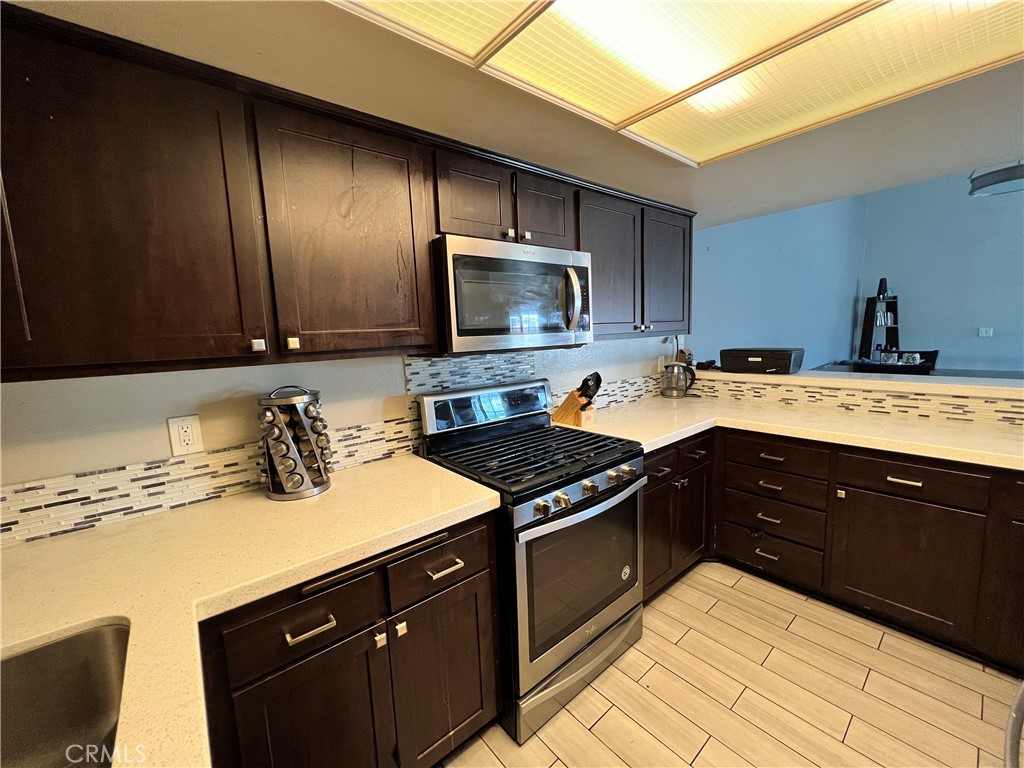 22031 Main, Unit 10 Carson, CA 90745 - Photo 9 of 10 a kitchen with a sink stove top oven and cabinets