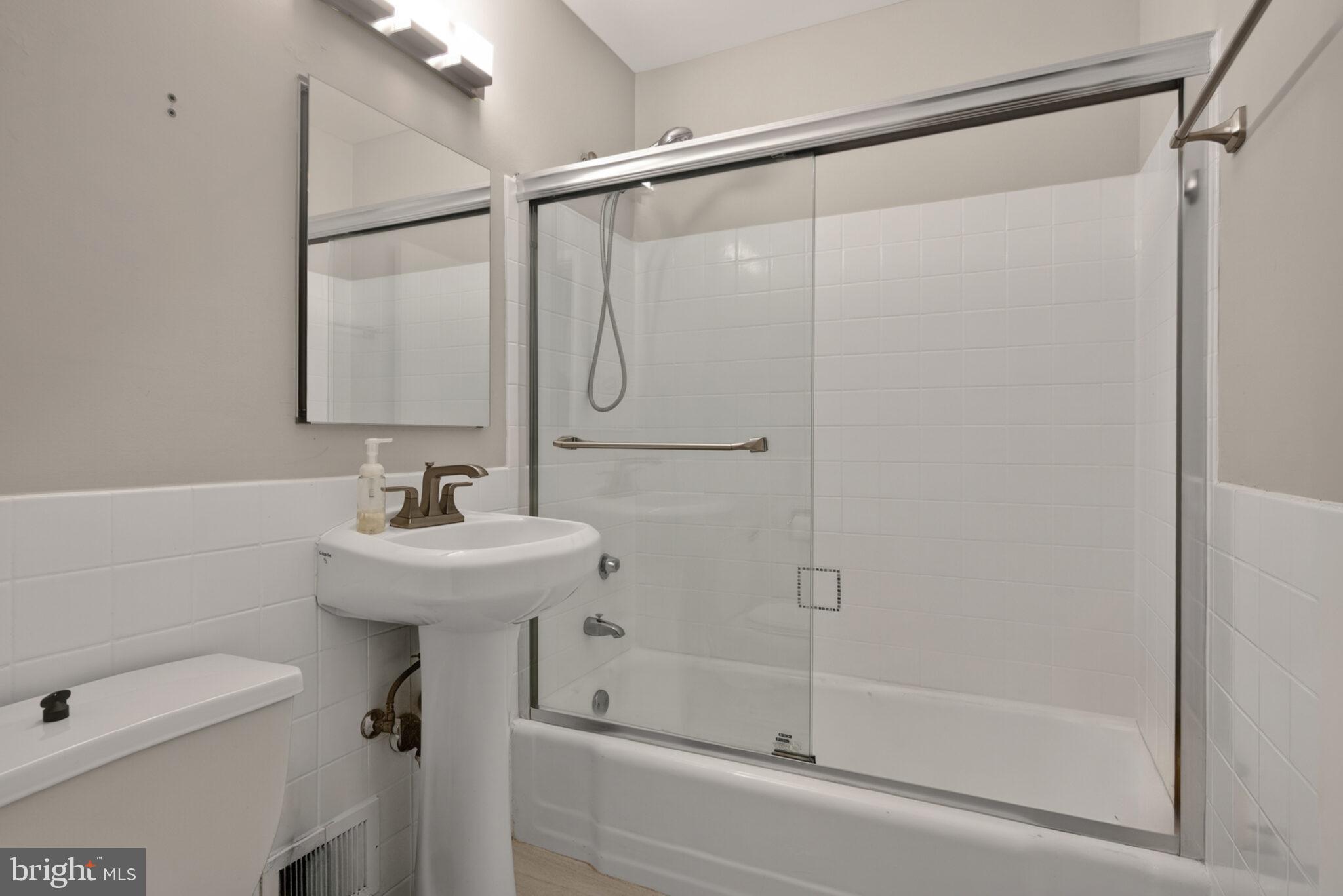 302 N Street Southwest, Unit 302 Washington, DC 20024 - Photo 25 of 68 a bathroom with a sink a mirror and a shower