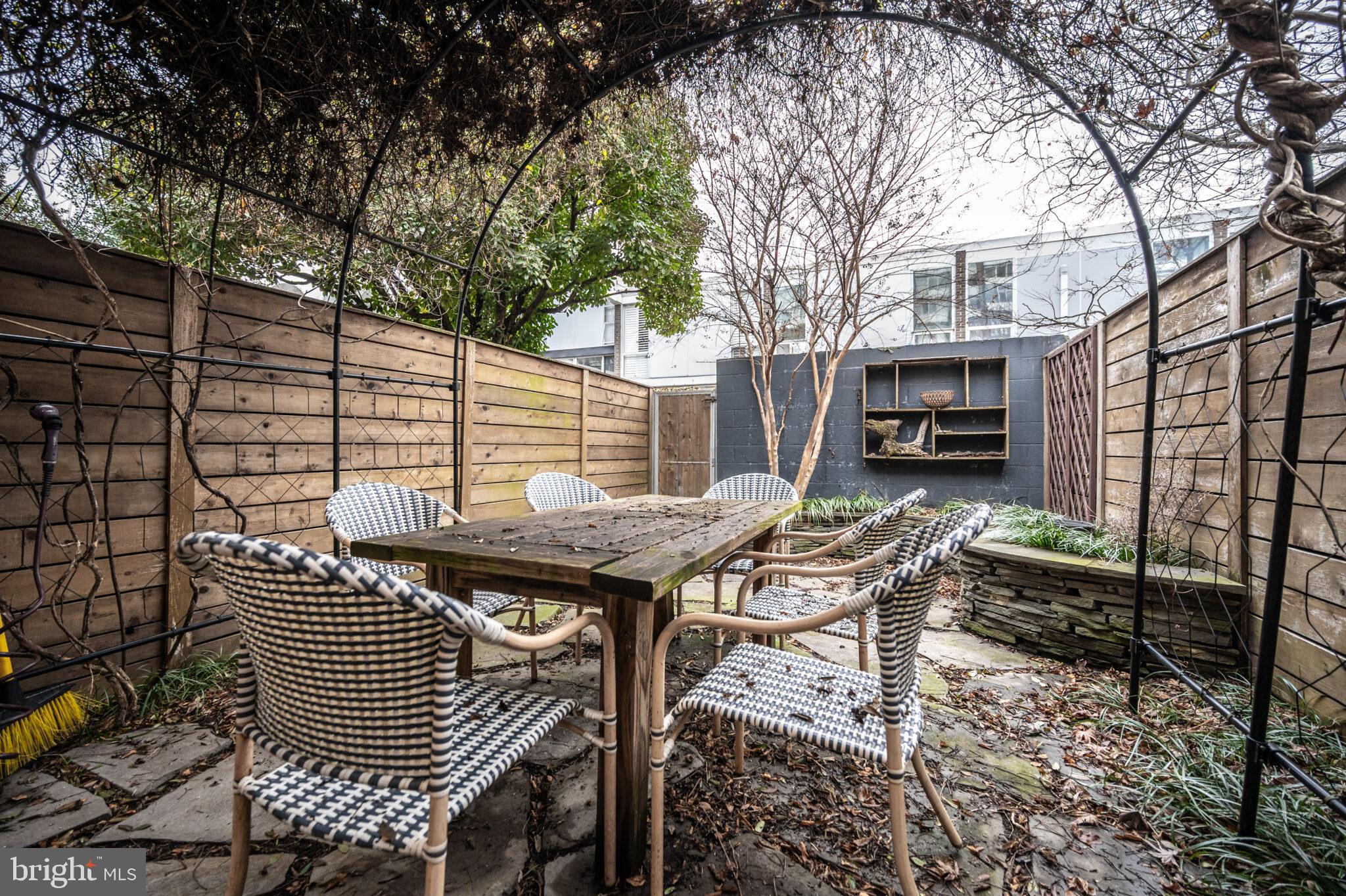 302 N Street Southwest, Unit 302 Washington, DC 20024 - Photo 38 of 68 a view of a patio with a table and chairs and wooden fence