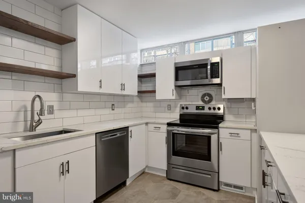 a kitchen with white cabinets and appliances