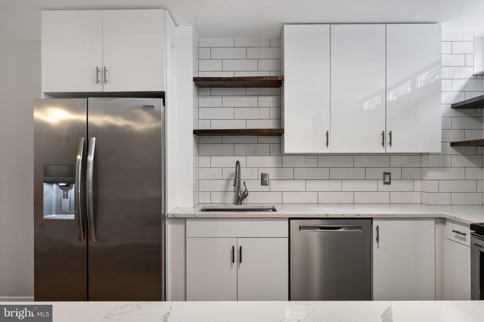 302 N Street Southwest, Unit 302 Washington, DC 20024 - Photo 8 of 68 a kitchen with stainless steel appliances granite countertop a refrigerator a sink and white cabinets
