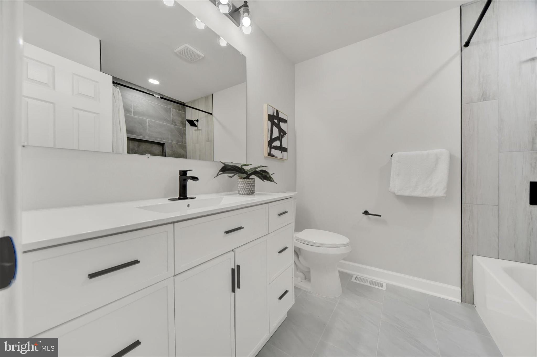 3808 Perryhurst Place Baltimore, MD 21236 - Photo 14 of 29 a bathroom with a toilet sink and mirror