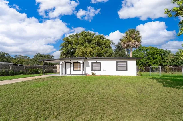 a front view of a house with a yard and trees