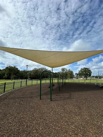 a view of swimming pool with lawn chairs and iron fence