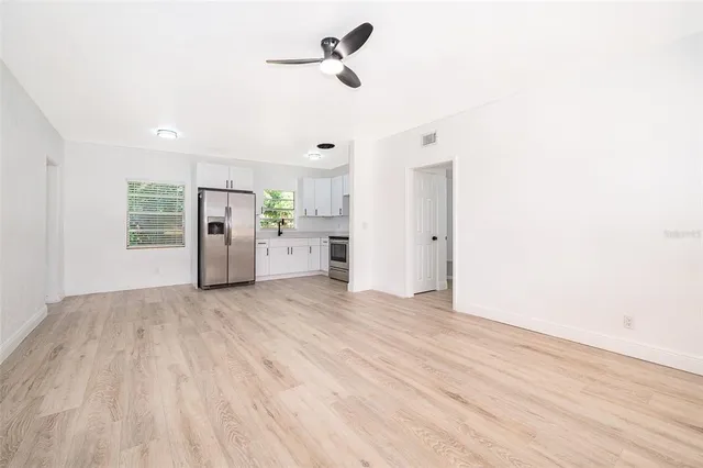 a view of empty room with wooden floor and windows