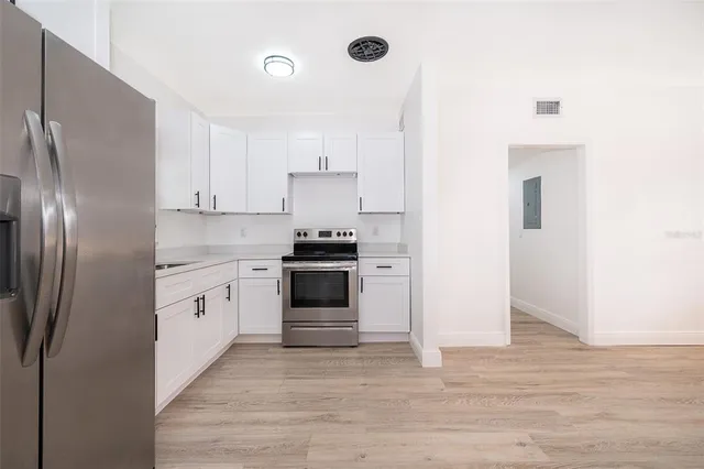 a kitchen with granite countertop white cabinets and stainless steel appliances