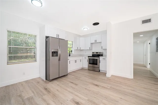 a kitchen with stainless steel appliances a refrigerator and a stove top oven