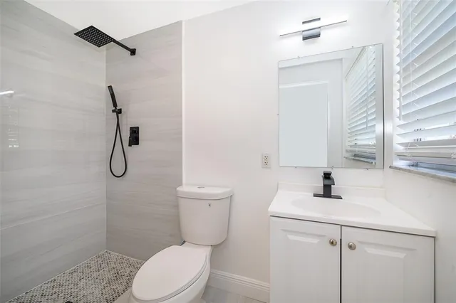 a bathroom with a toilet sink vanity and shower