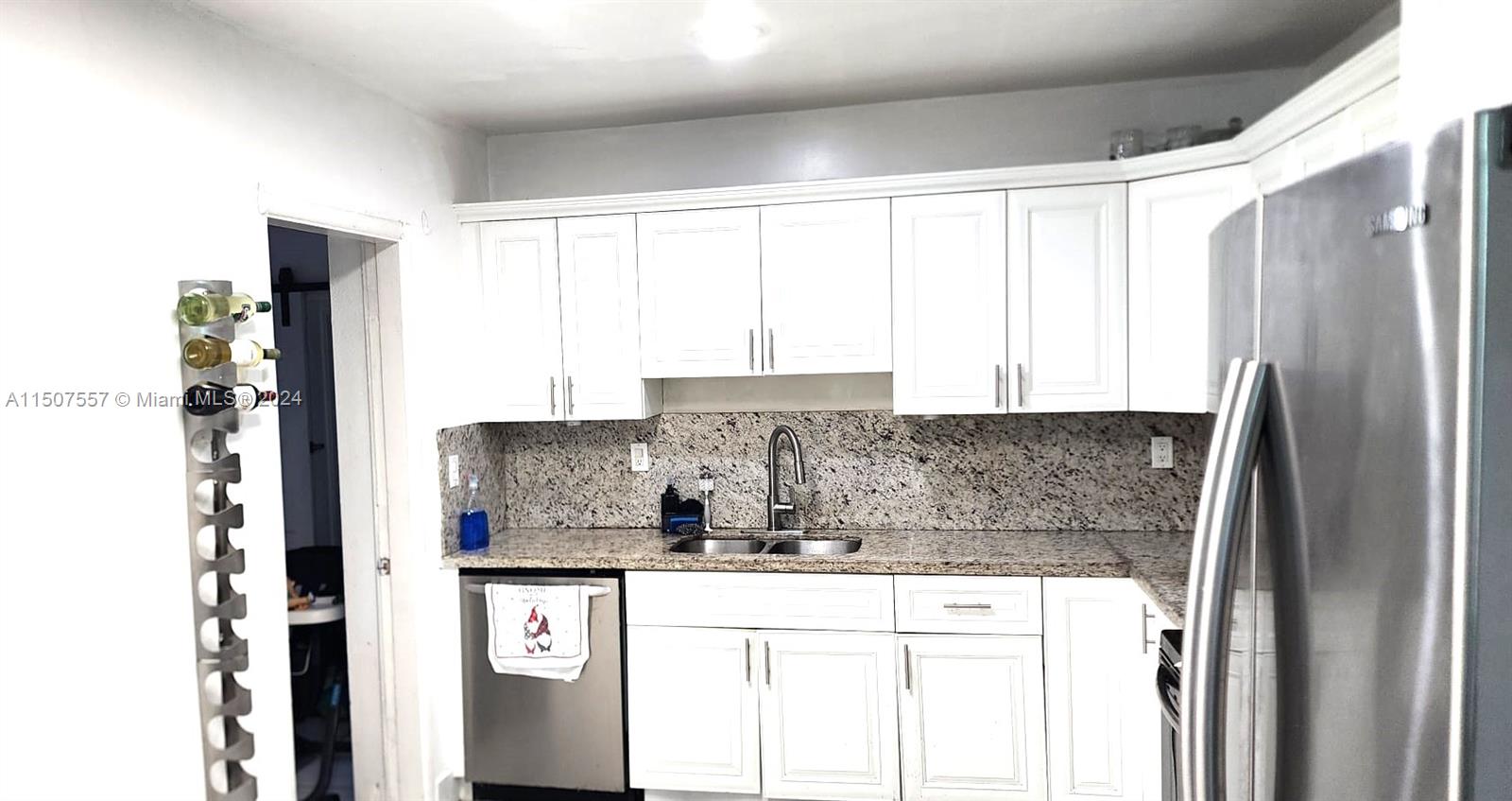 12441 Southwest 190th Terrace Miami, FL 33177 - Photo 10 of 24 a kitchen with stainless steel appliances granite countertop a refrigerator and white cabinets