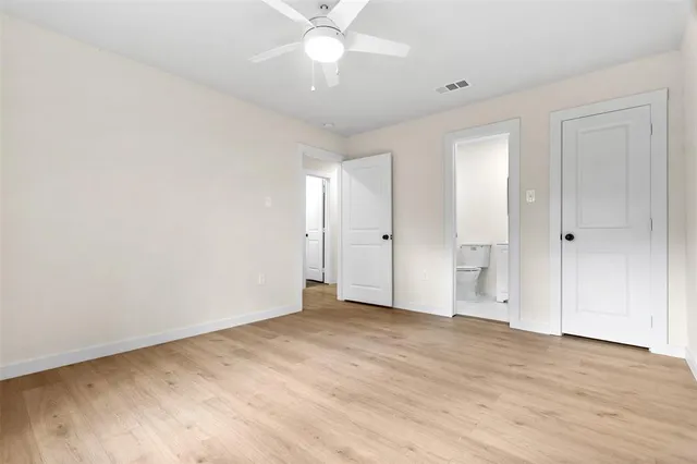 an empty room with fan and entrance