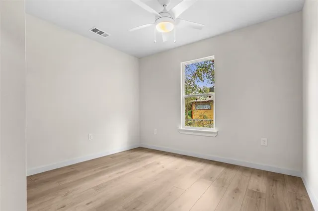 an empty room with a window and wooden floor