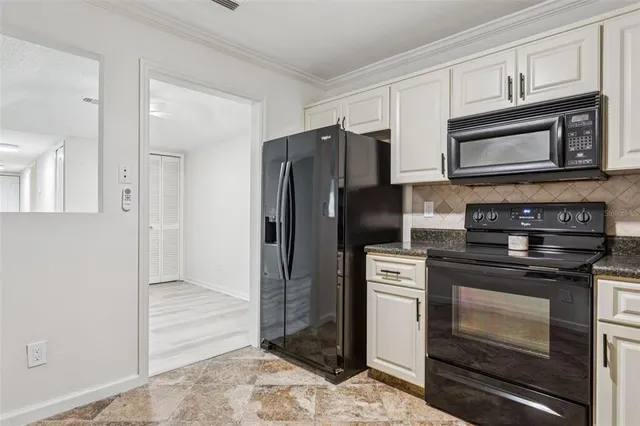 a kitchen with stainless steel appliances granite countertop a refrigerator stove and sink