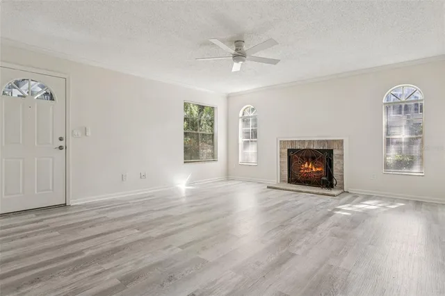 an empty room with windows fireplace and a sink