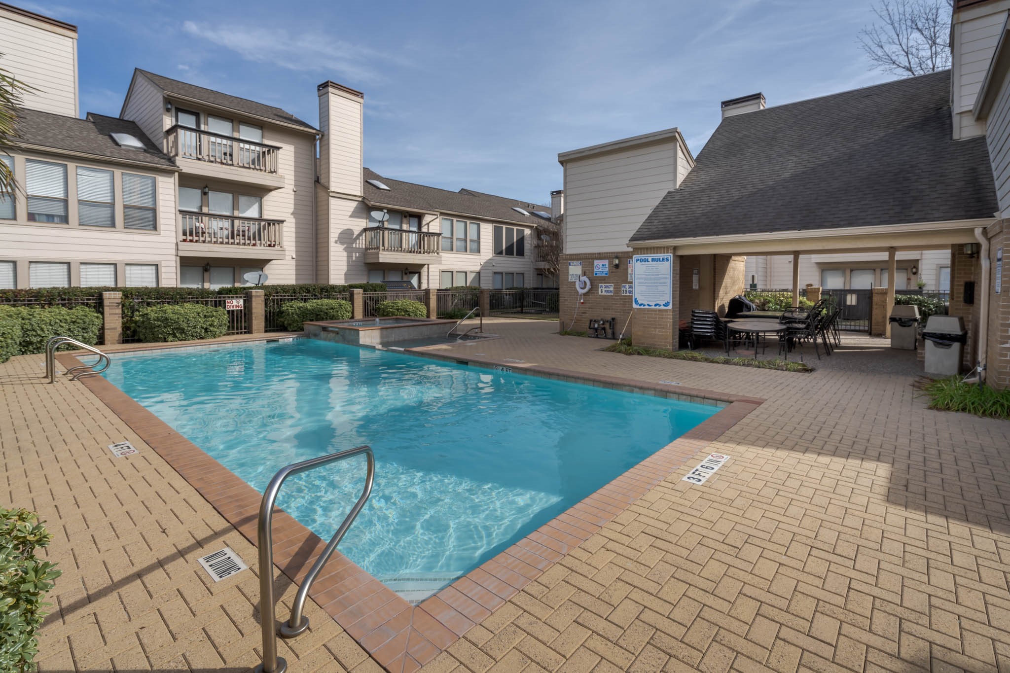 2277 South Kirkwood Road, Unit 4/808 Houston, TX 77077 - Photo 1 of 23 Communal outdoor area featuring a swimming pool with surrounding paved patio space and several multi-story residential buildings. It offers a relaxing environment with shaded seating, perfect for leisure and social gatherings.