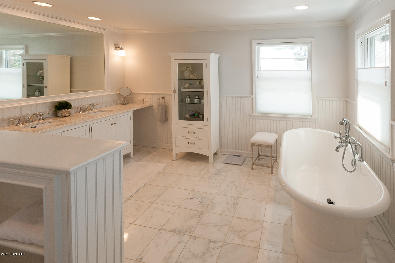49 Indian Field Road Greenwich, CT 06830 - Photo 19 of 28 a en suite bathroom with a double vanity sink a mirror and a bathtub
