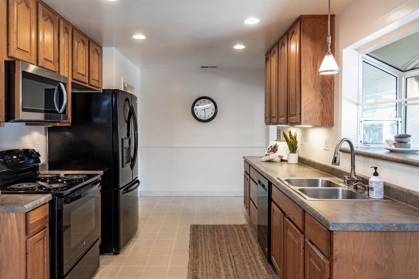 866 Stonehurst Way Campbell, CA 95008 - Photo 6 of 18 a kitchen with granite countertop a refrigerator a sink and wooden cabinets