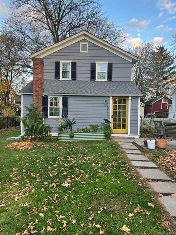a front view of a house with a yard and trees