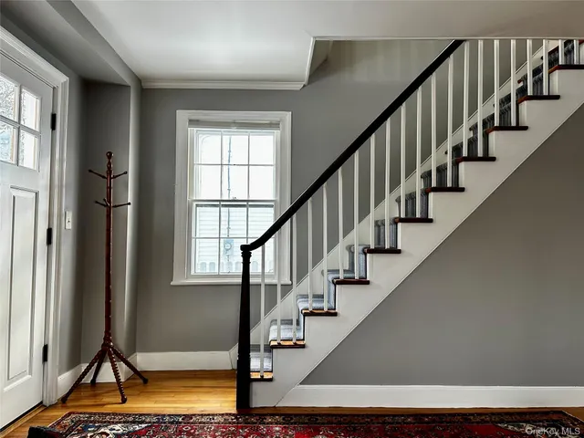 a view of entryway with wooden floor and stairs