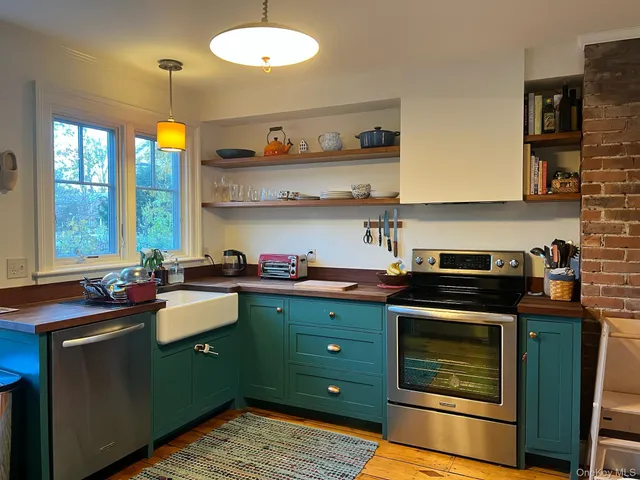 a kitchen that has a sink a stove and a refrigerator