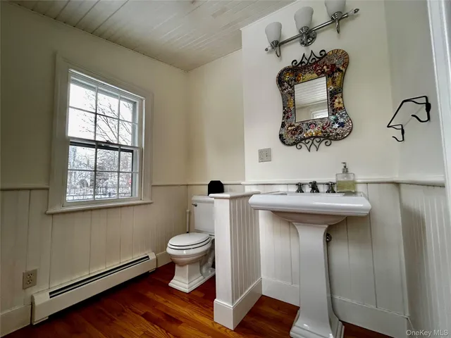 a bathroom with a sink toilet and mirror