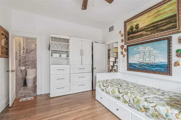 a bedroom with a bed and wooden floor