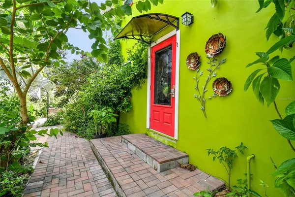 a front view of a building with red door and a couch