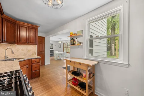 a living room with stainless steel appliances granite countertop a stove and a sink