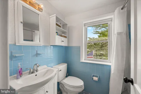 a bathroom with a sink a toilet and a window