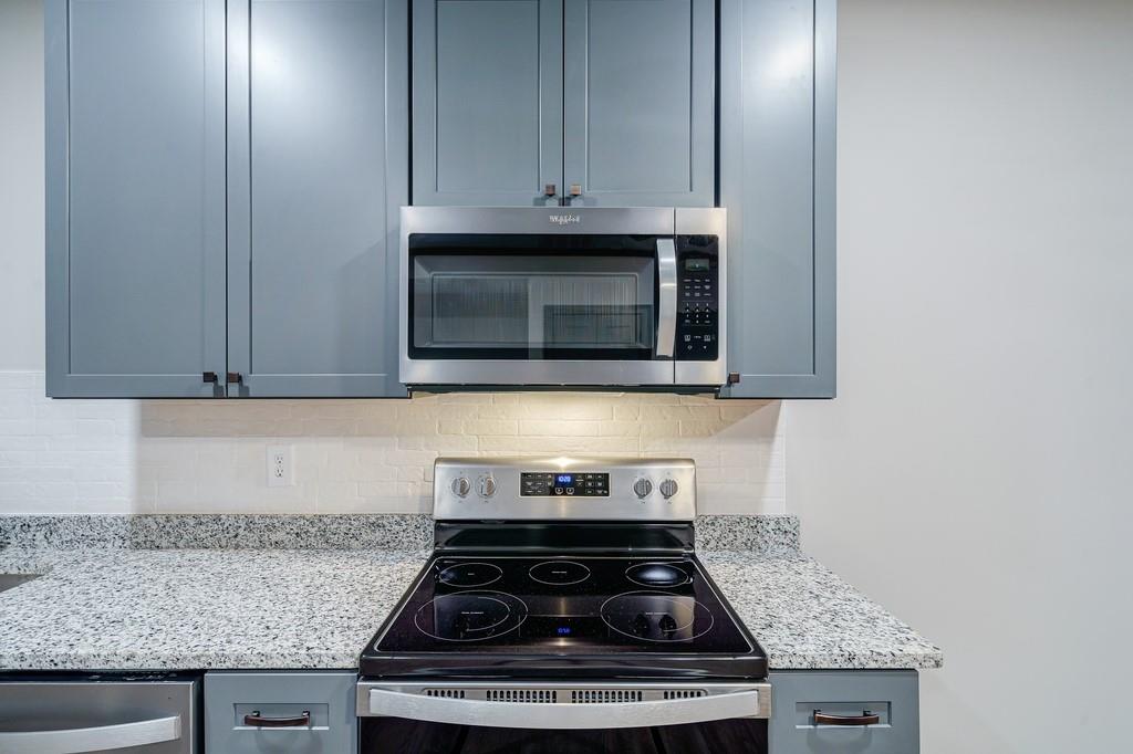 34 Depot Street, Unit 22 Hartwell, GA 30643 - Photo 13 of 29 a kitchen with stainless steel appliances granite countertop white cabinets and a stove top oven