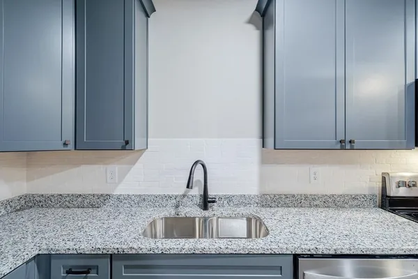 a kitchen with granite countertop a sink and cabinets
