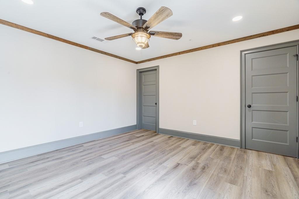 34 Depot Street, Unit 22 Hartwell, GA 30643 - Photo 28 of 29 an empty room with a ceiling fan and wooden floor