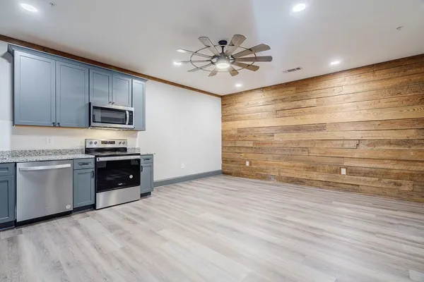 a kitchen with granite countertop a stove and cabinets