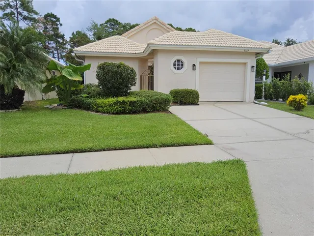 a front view of a house with a garden and plants