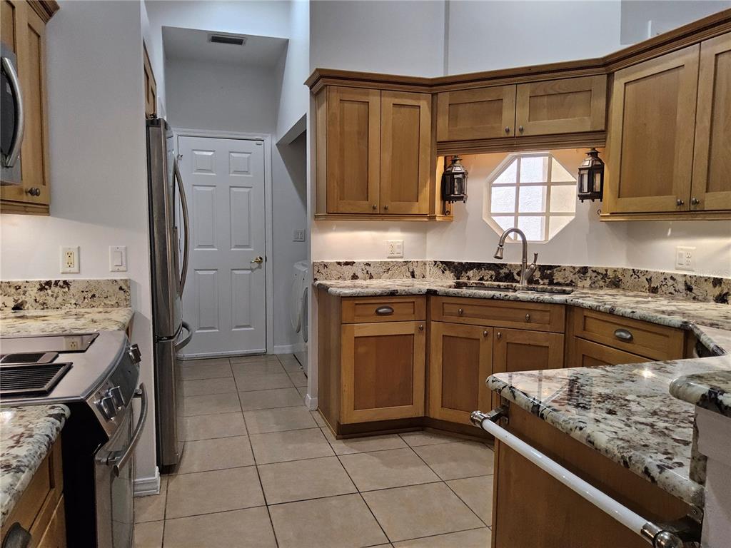 8023 St Andrews Way Mount Dora, FL 32757 - Photo 18 of 28 a kitchen with a stove top oven sink and cabinets