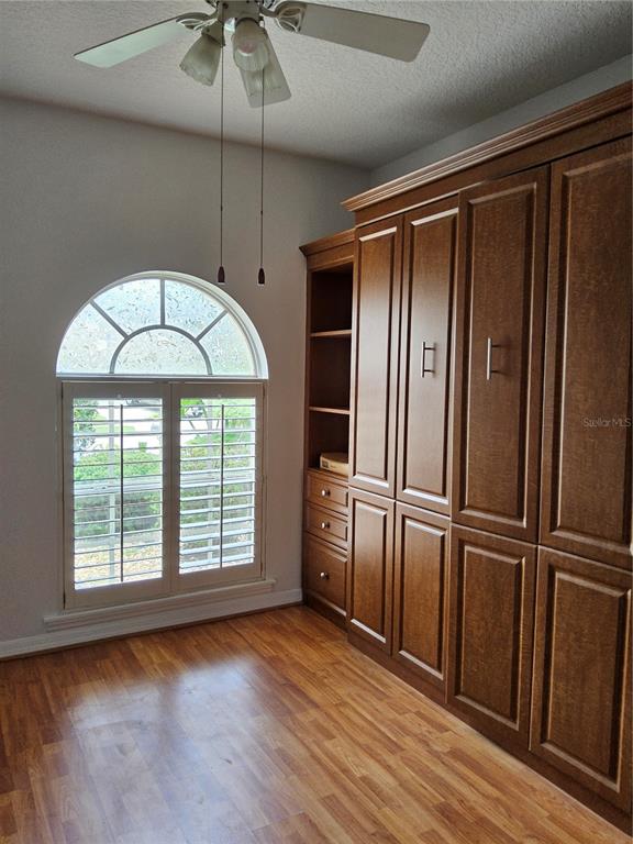 8023 St Andrews Way Mount Dora, FL 32757 - Photo 5 of 28 an empty room with wooden floor fan and windows