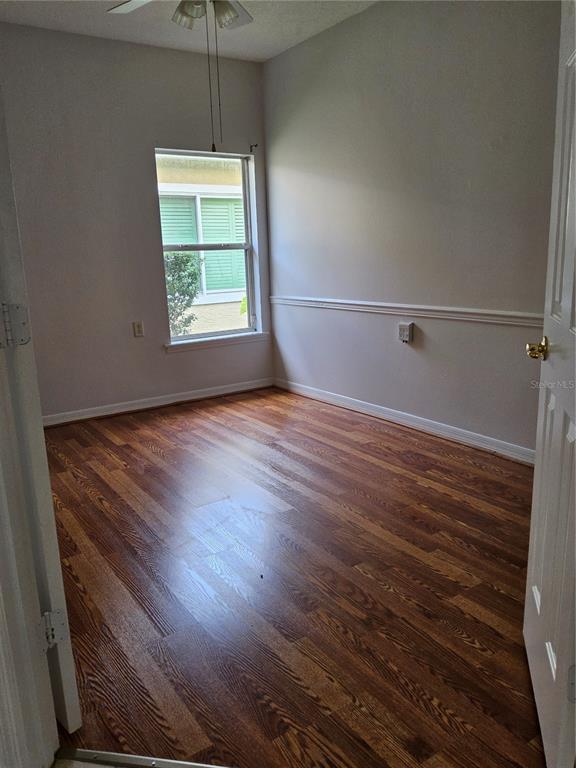 8023 St Andrews Way Mount Dora, FL 32757 - Photo 8 of 28 an empty room with wooden floor a ceiling fan and windows