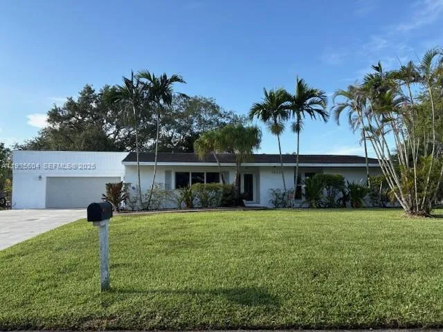 a view of a house with a yard and palm tree