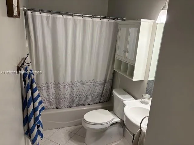 a white toilet sitting next to a shower curtain