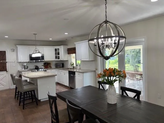 a kitchen with a dining table chairs and view of living room