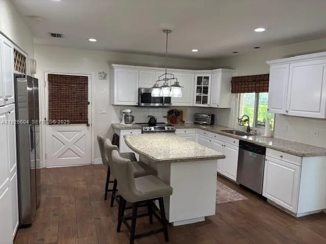 a kitchen with stainless steel appliances granite countertop a sink a stove and a refrigerator