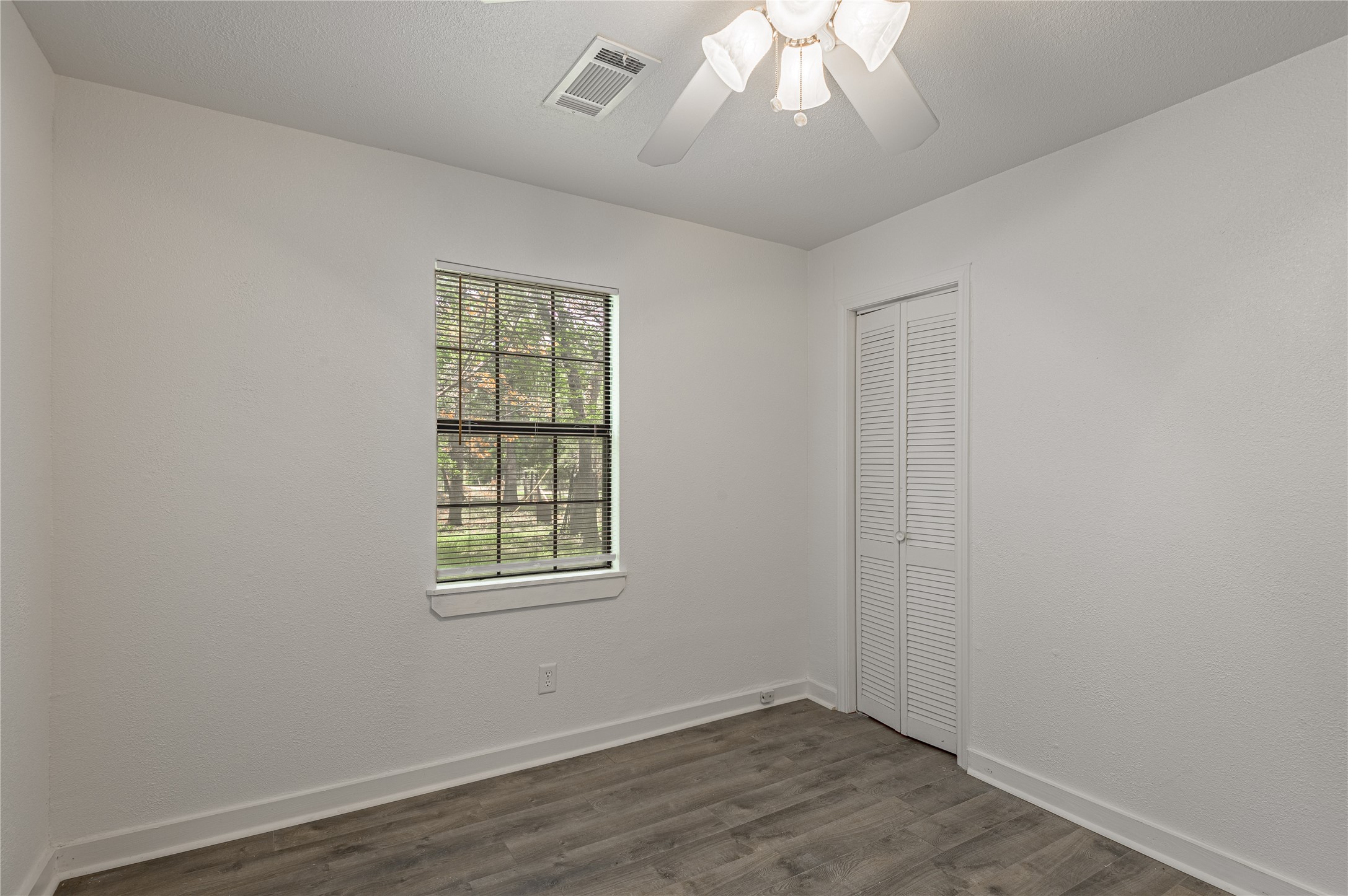 7 A Hickory Lane Huntsville, TX 77340 - Photo 12 of 36 an empty room with wooden floor and windows