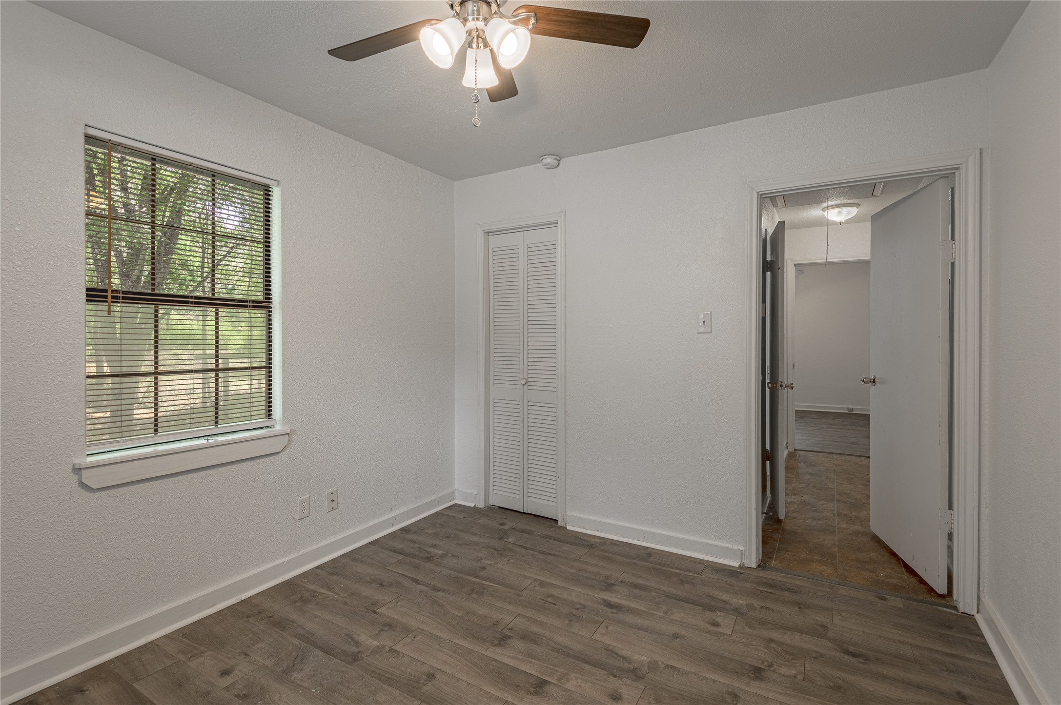 7 A Hickory Lane Huntsville, TX 77340 - Photo 18 of 36 an empty room with wooden floor and windows